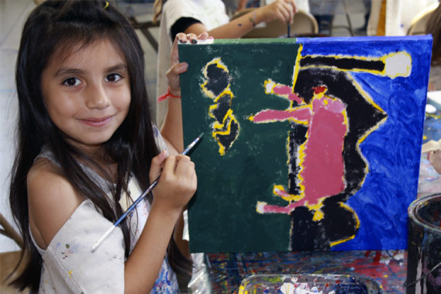 elementary student showcasing painting