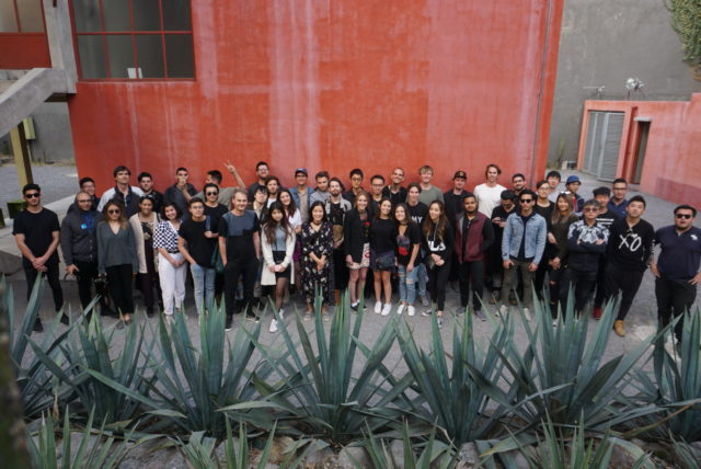 students in mexico next to red orange structure