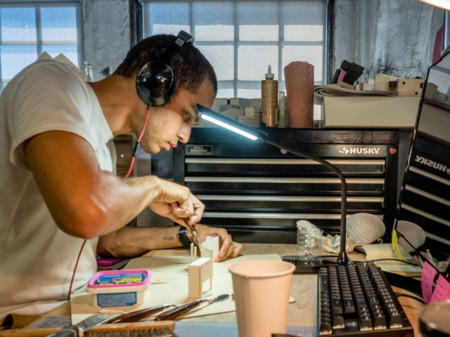 student wearing headphones making a model