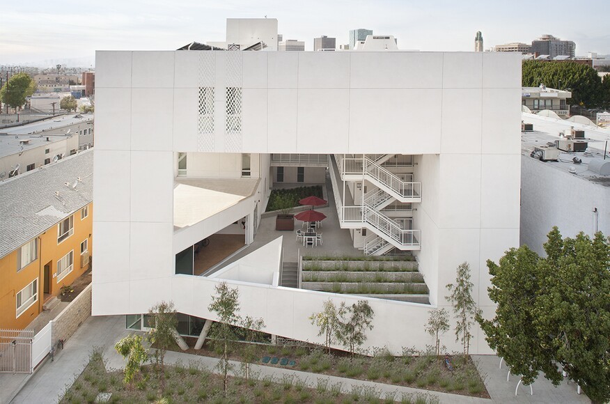 Photo of white building with open interior architecture The Six Affordable Veteran Housing, designed by Brooks + Scarpa, Los Angeles, CA