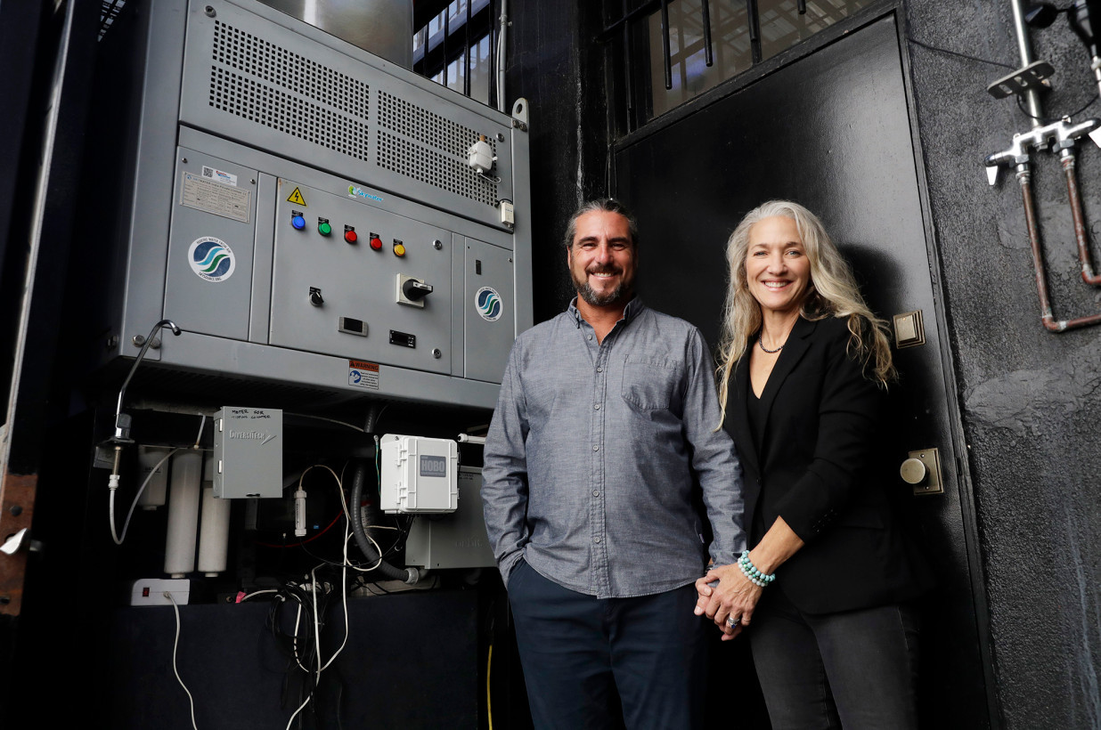 a couple standing next to an electric board