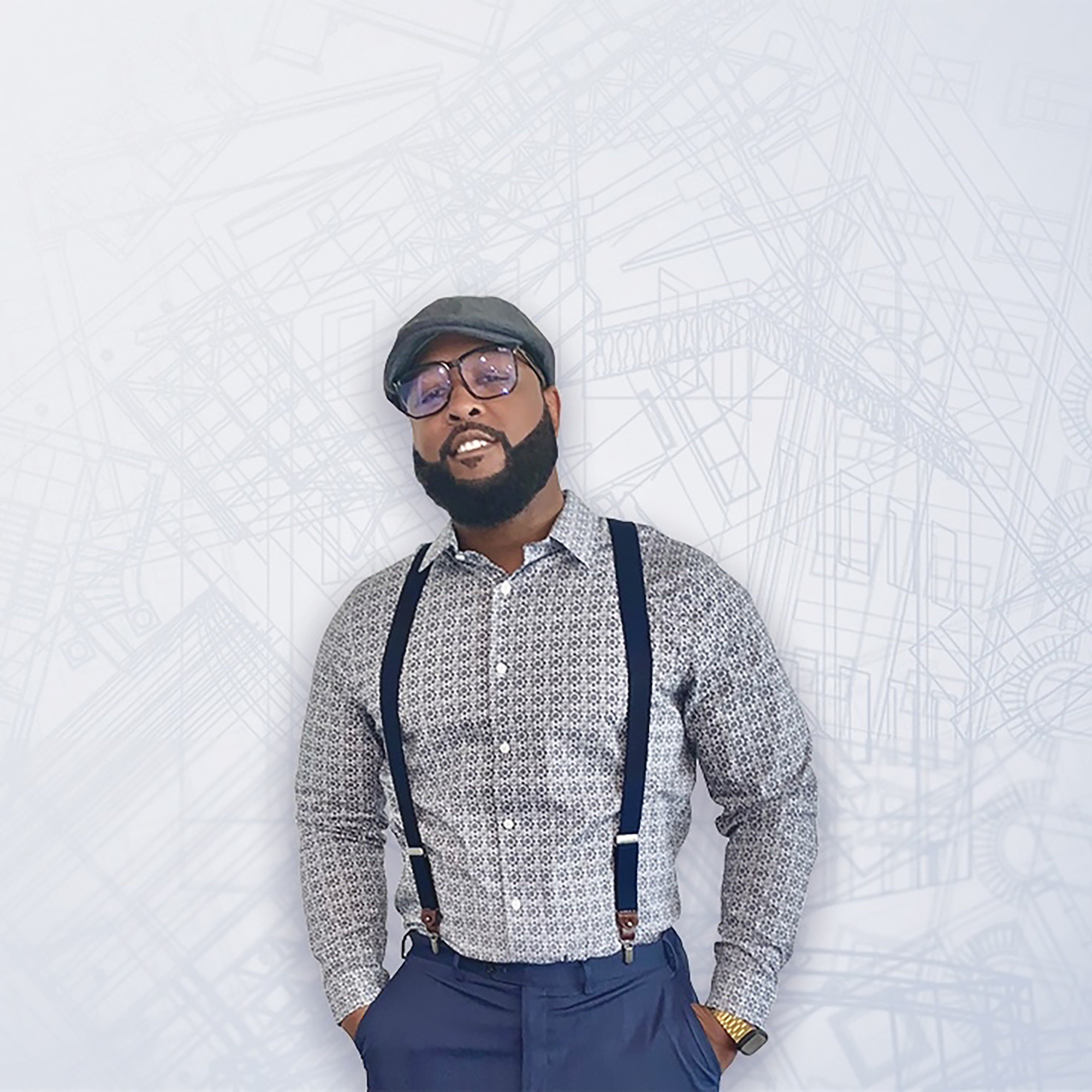 man leaning against a wall smiling in suspenders