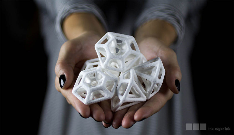 a lady holding multiple small 3D prints in her hands