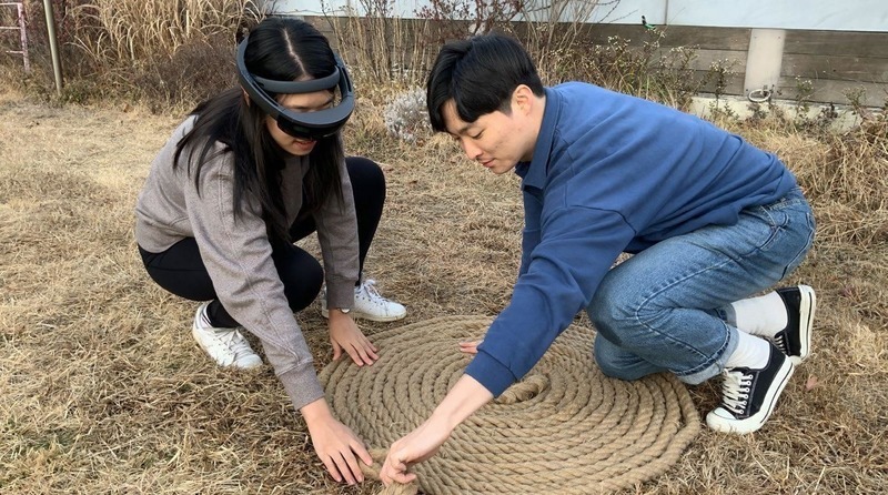 two people winding rope