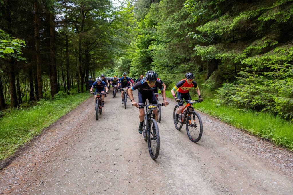Mountain bikers racing on a forest fireroad, Hillside Outside