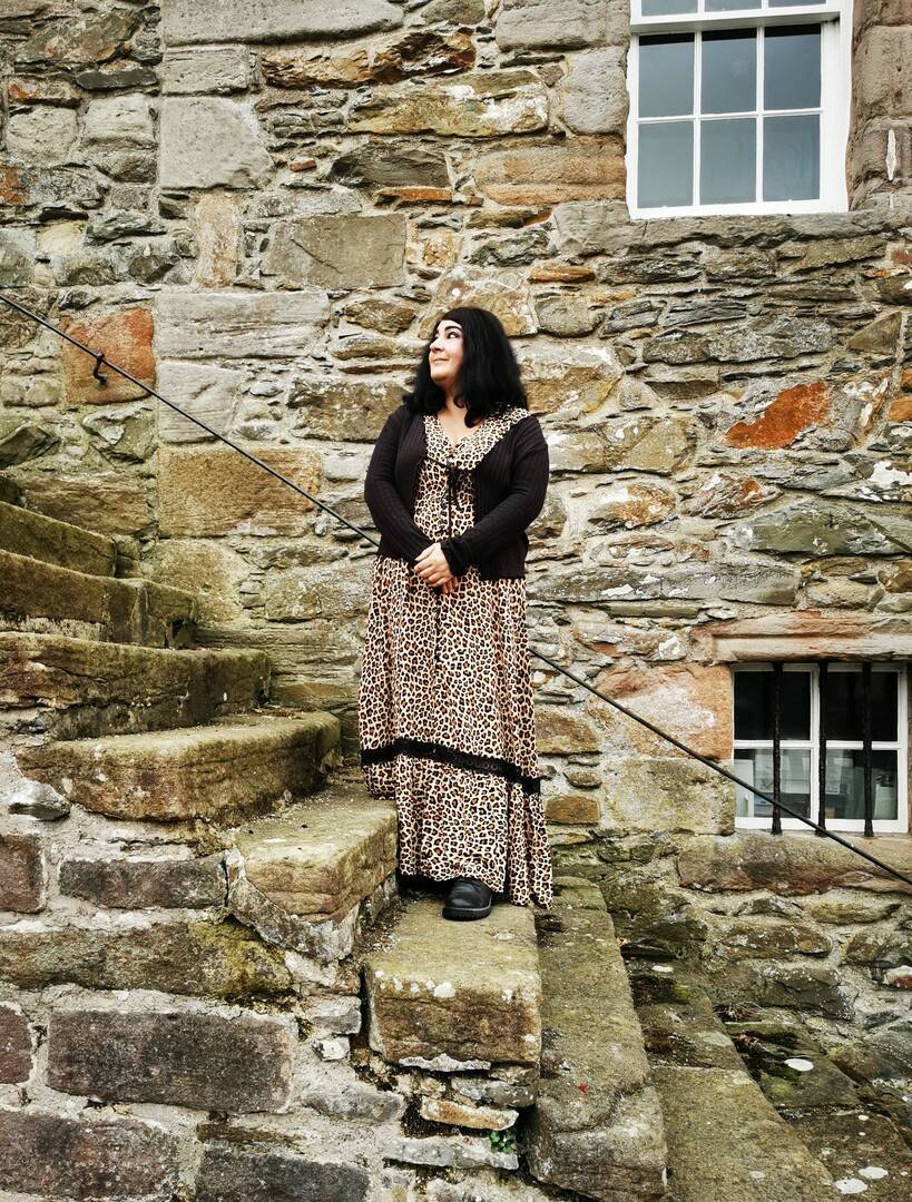 Storyteller Kathleen Cronie standing on the stone steps at Kirkcudbright Tolbooth where Jean Maxwell, The Galloway Sorceress, was imprisoned, Mostly Ghostly