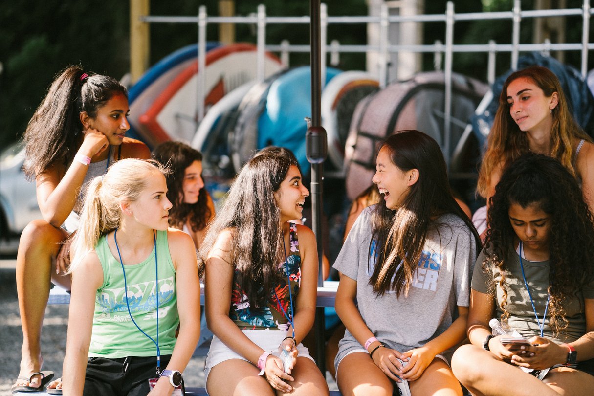 Female students sitting while talking and laughing