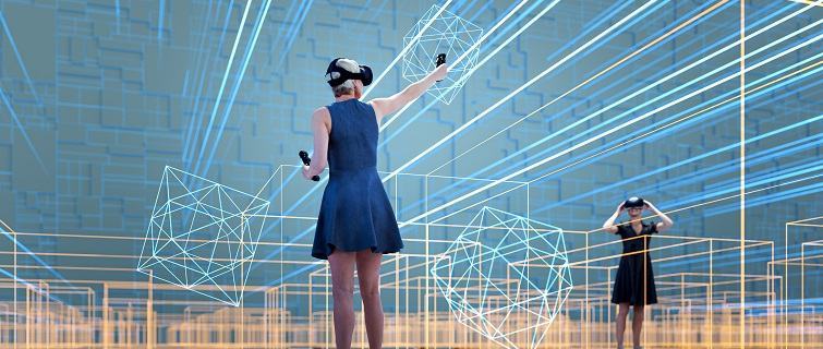 Two women using VR headsets in a 3D generated image full of orange, yellow and blue geometric shapes.