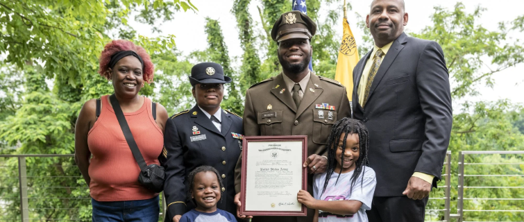 Lester Mungro poses with family outside on Georgetown University campus while holding award.