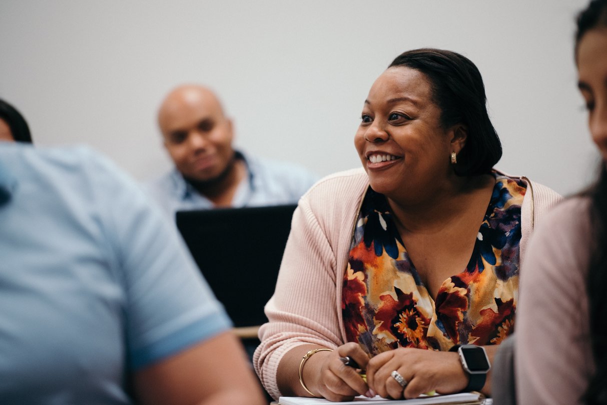 Woman smiling in classroom during lecture.