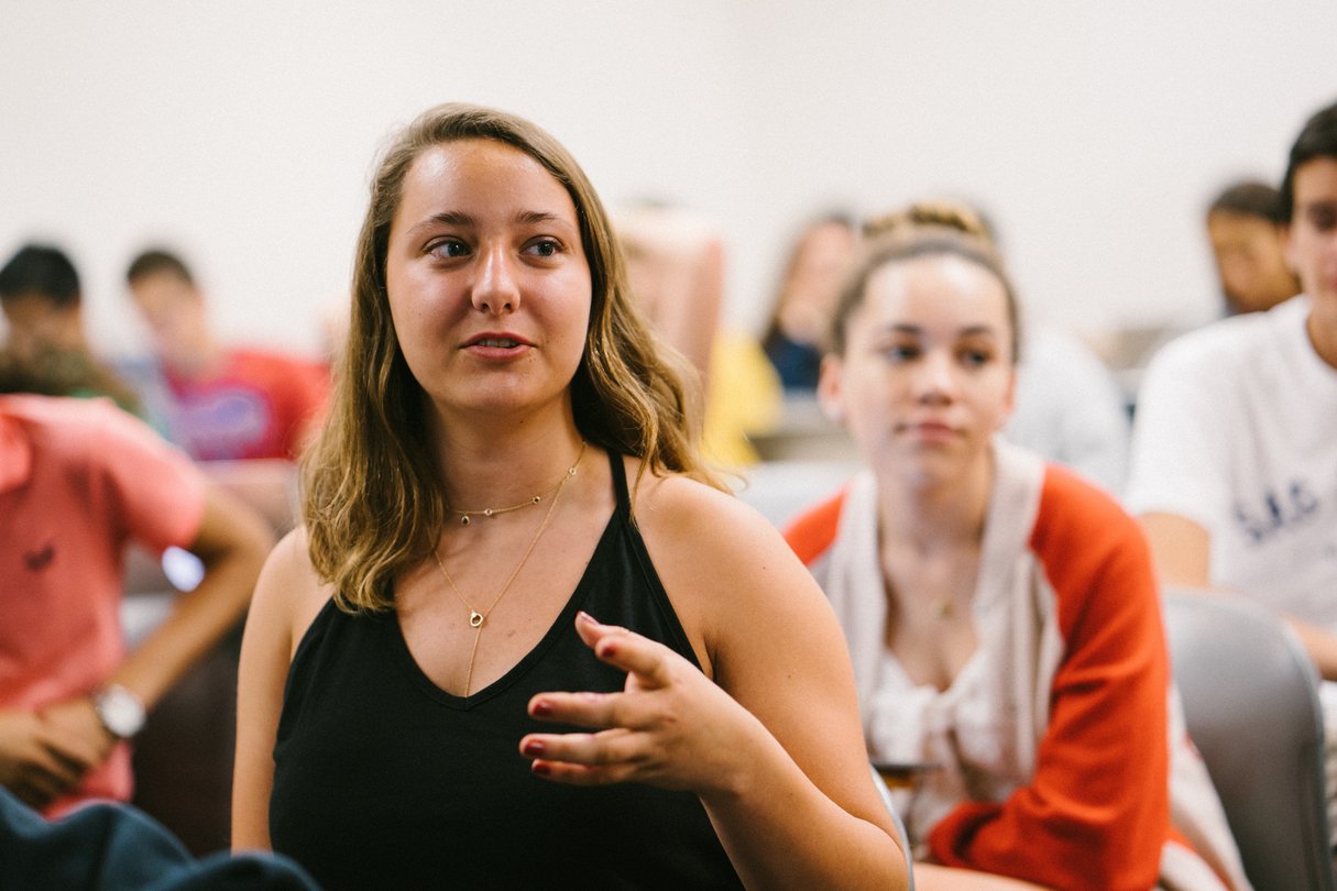 Close up of female student talking in lecture hall.