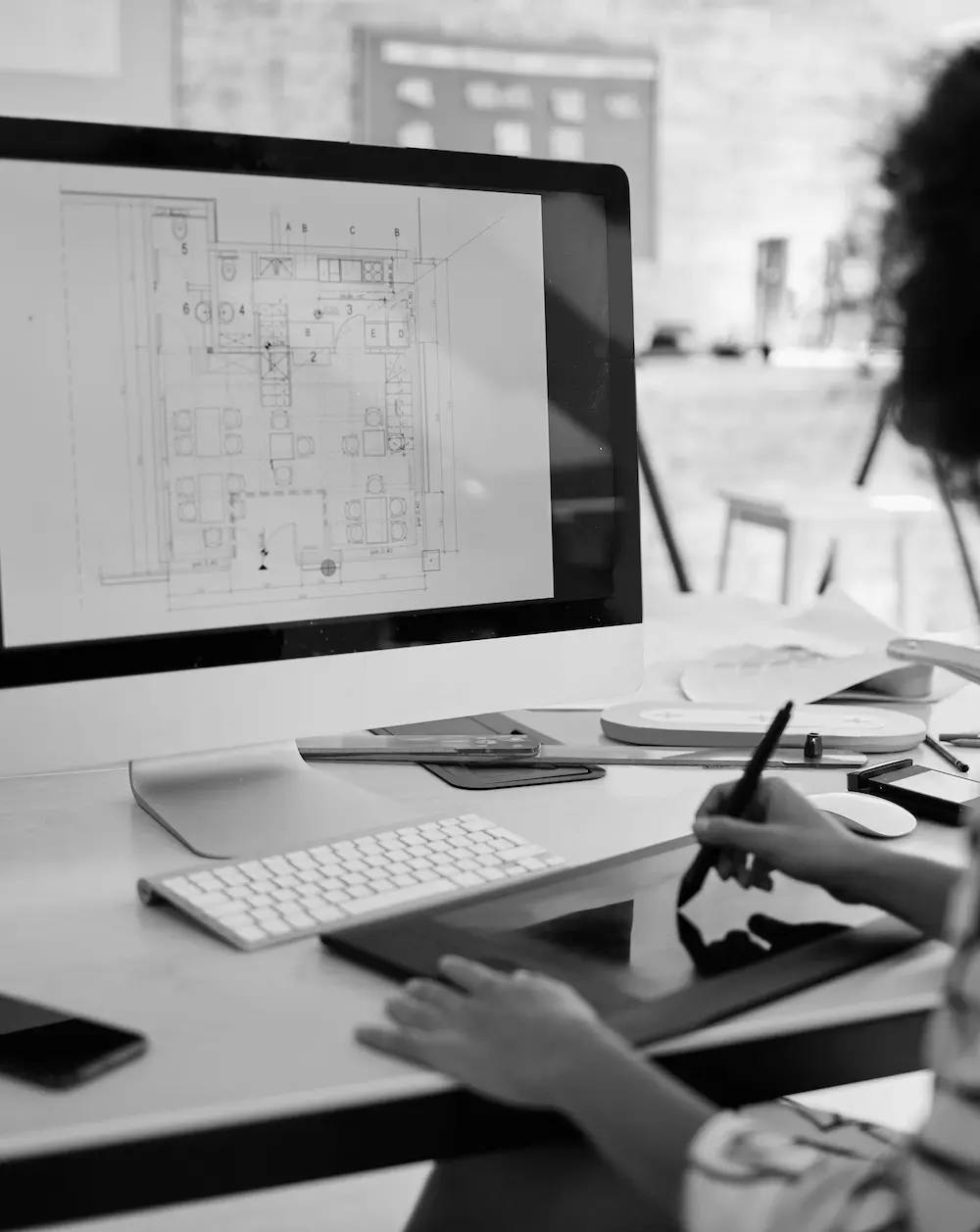 Someone working on a drawing tablet in front of a computer.