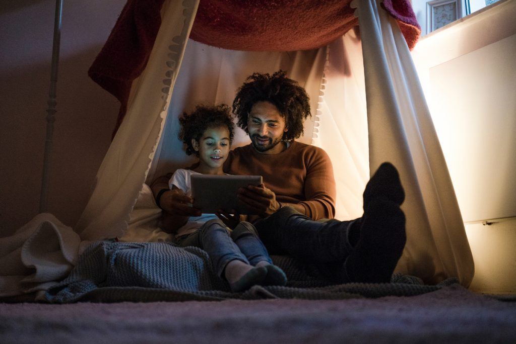 father and child build an indoor tent to stay warm in a cold house