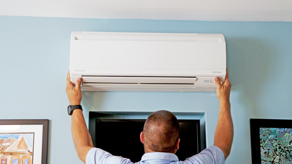 professional installs indoor mini split AC unit in older home