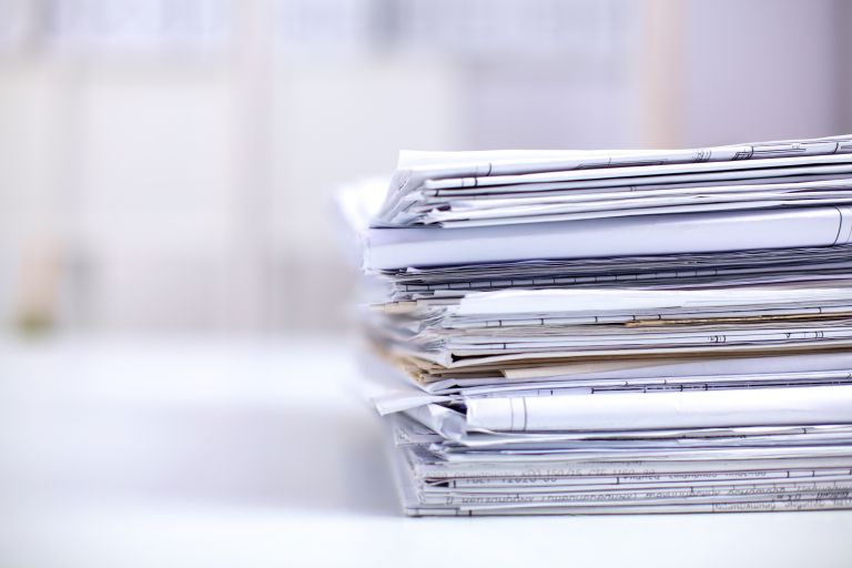 Big stack of papers, documents on the desk.