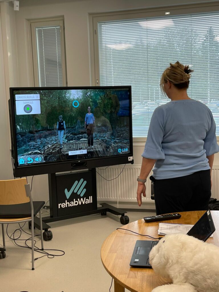 A woman standing in front of a giant screen.