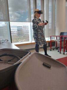Nainen seisoo opetustuilanteessa VR-lasit päässä.
