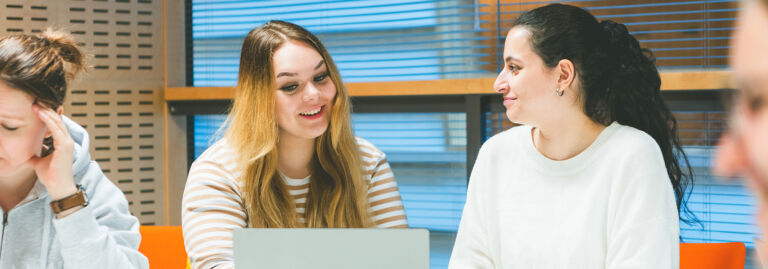 Opiskelijoita istuu ja juttelee. / Students sitting and talking.