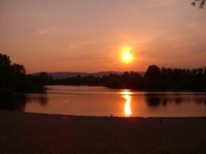 Auringonlasku järven yllä.