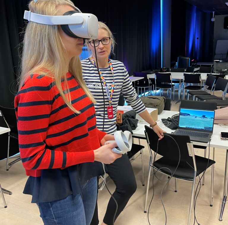 Henkilö katsoo Antti Railion metaverse-esitystä VR-laseilla.