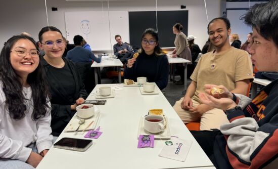 People sitting around a table having coffee.