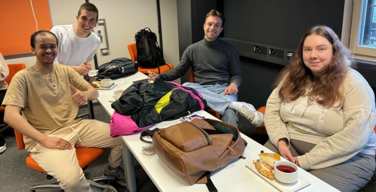 Four persons sitting around a table.