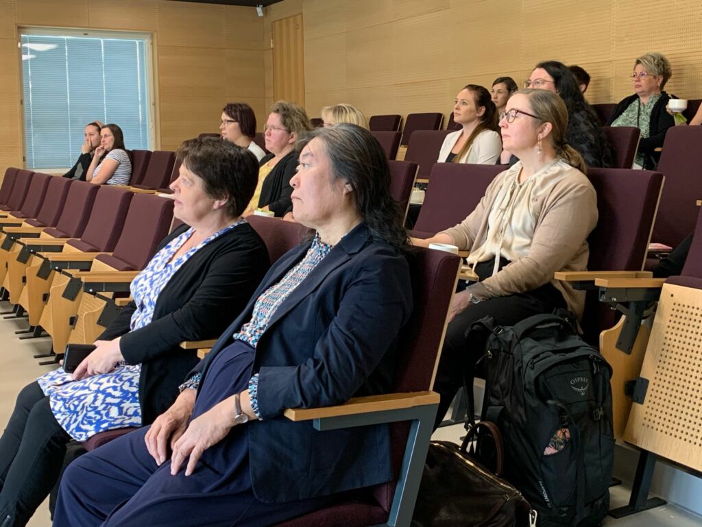 Yleisöä istumassa auditoriossa.