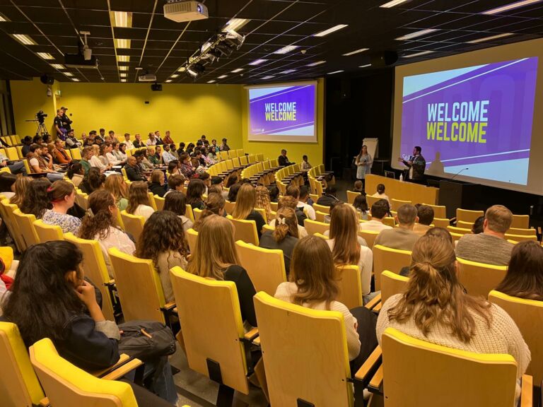 More than a hundred students in a big auditorium.