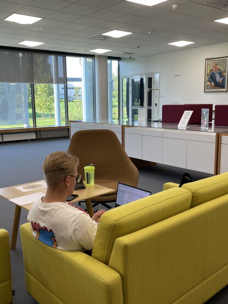 A person sitting on a couch writing a thesis.