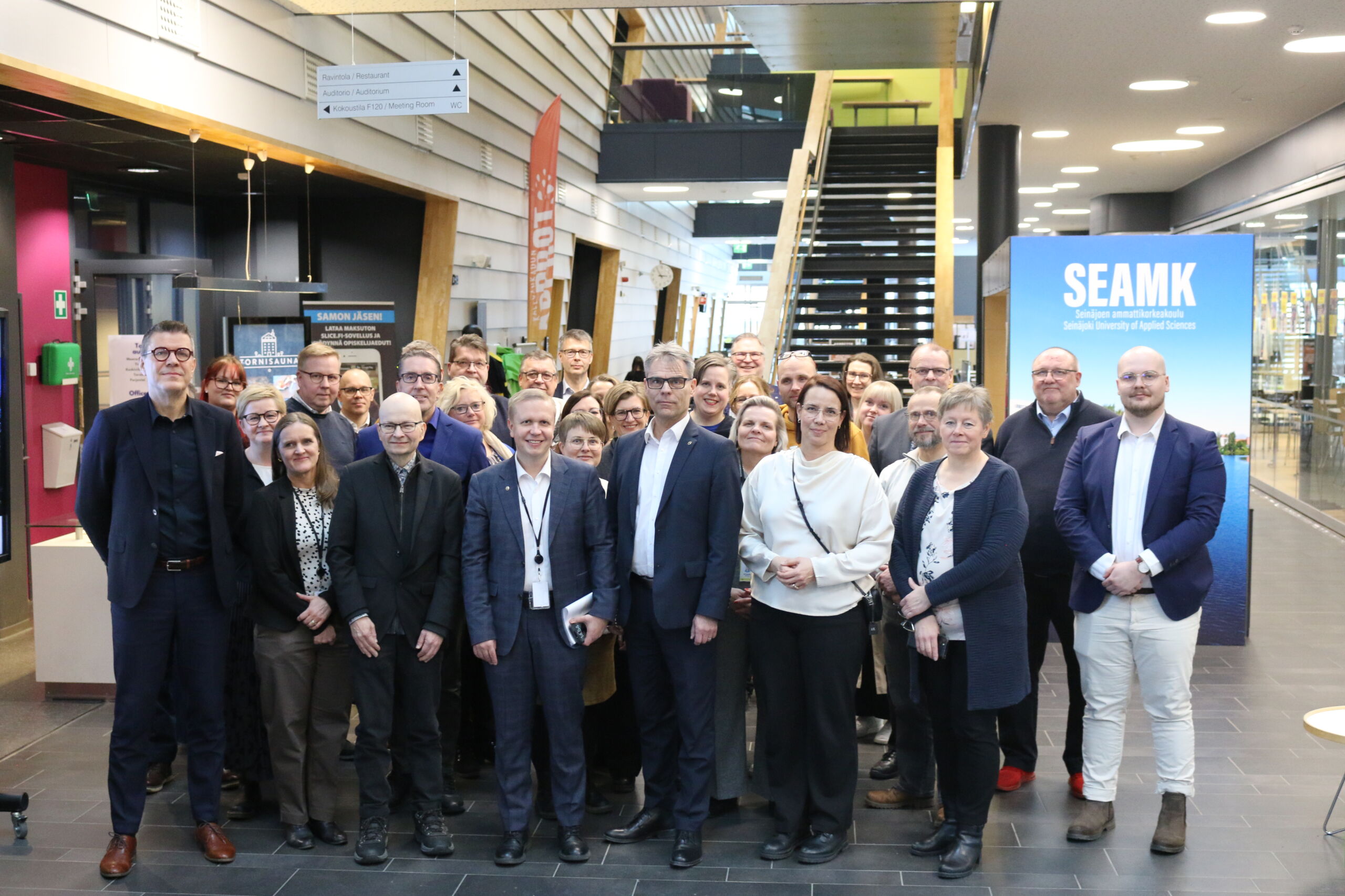 Noin 20 ihmisen ryhmä yhteiskuvassa.