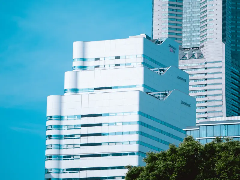 白い壁の端で、背後の高い建物が細くなった
