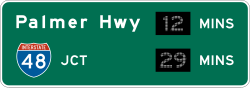 Post-interchange travel time information sign