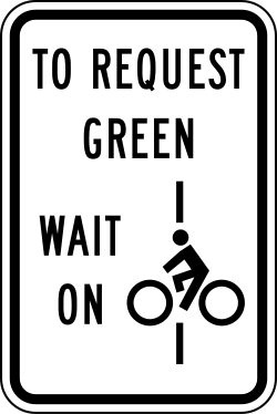 Instructs bicycles to wait on designated line to request green signal