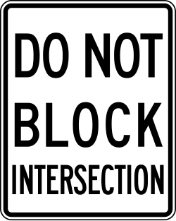 Prohibits vehicles from blocking the intersection