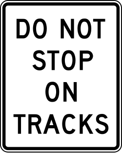 Prohibits stopping on or blocking railroad tracks