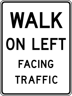 Instructs pedestrians to walk on the left side facing oncoming traffic