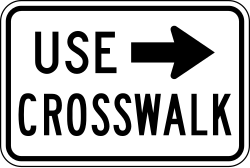 Supplemental plaque directing pedestrians to use designated crosswalk