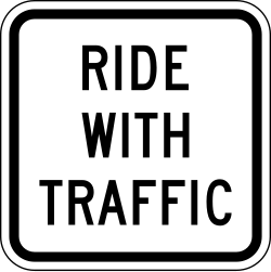 Supplemental plaque instructing cyclists to ride with traffic flow