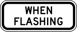 Supplemental plaque indicating rules apply when signal is flashing