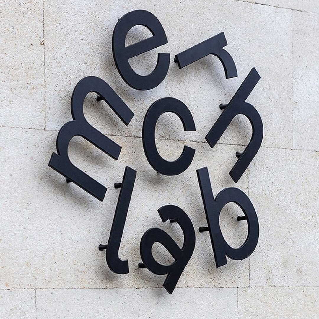 architectural typography, matte black on stone, spatial puzzle