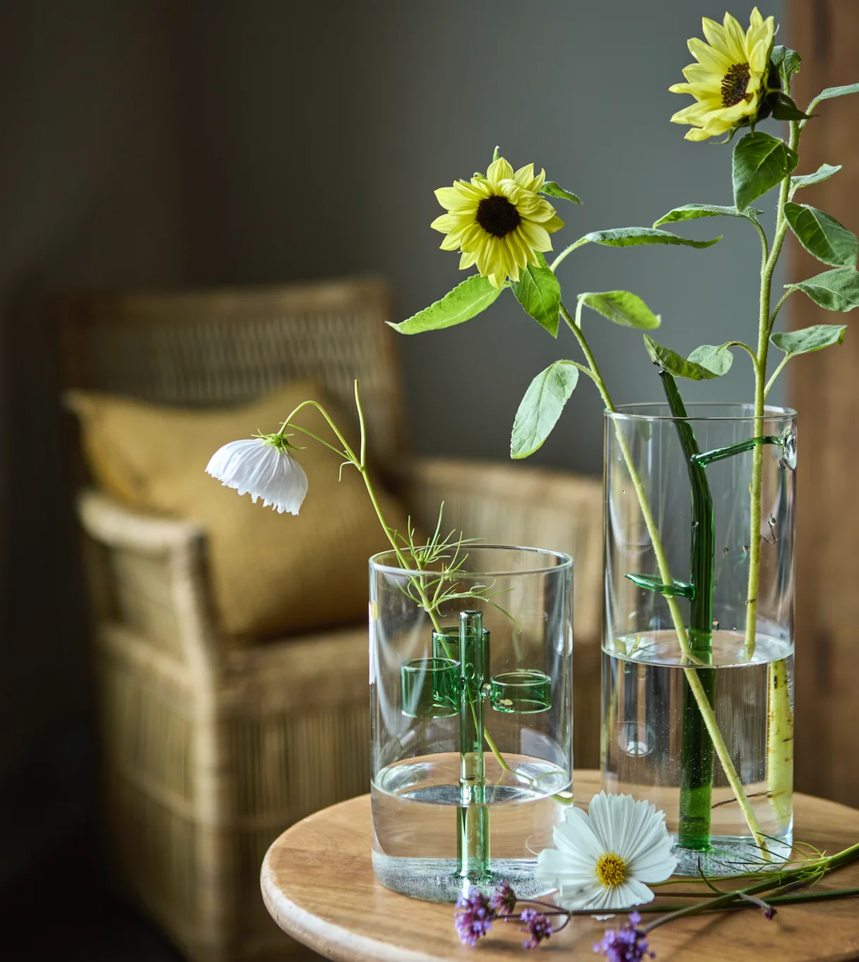 A bright and airy interior still-life featuring a textured ceramic urn, a minimalist candle, and budding spring branches bathed in soft natural sunlight.