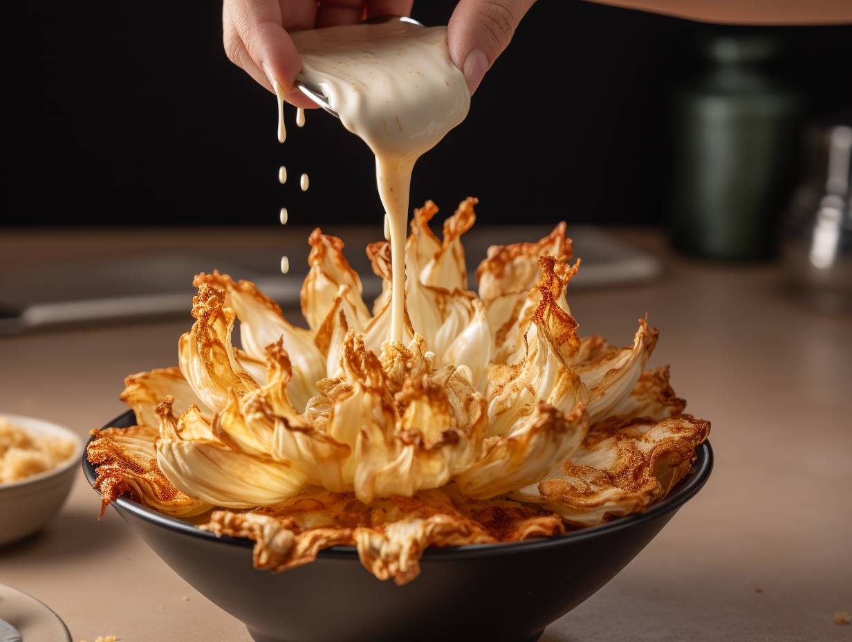 Hand dipping a blooming onion into seasoned batter for air frying