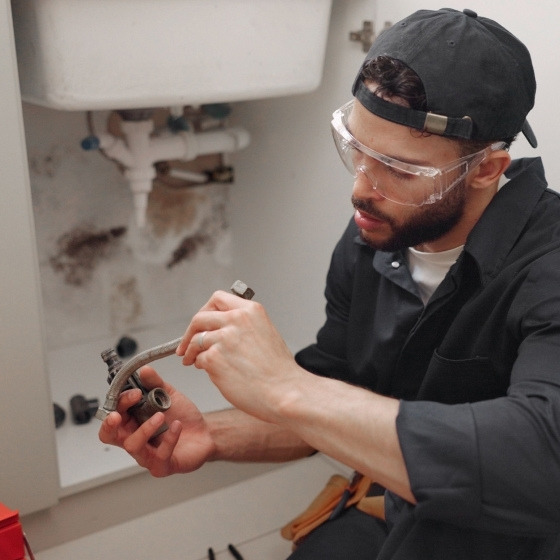 Plumber fixing the faulty pipeline | ServiceForge