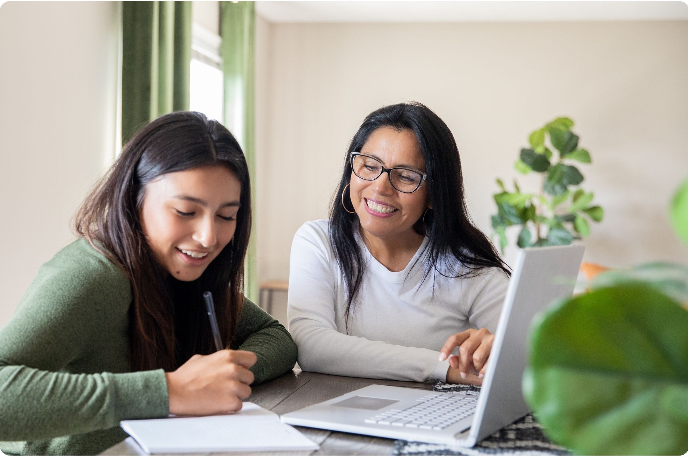 two women, one teacher, one student, laptop on desk