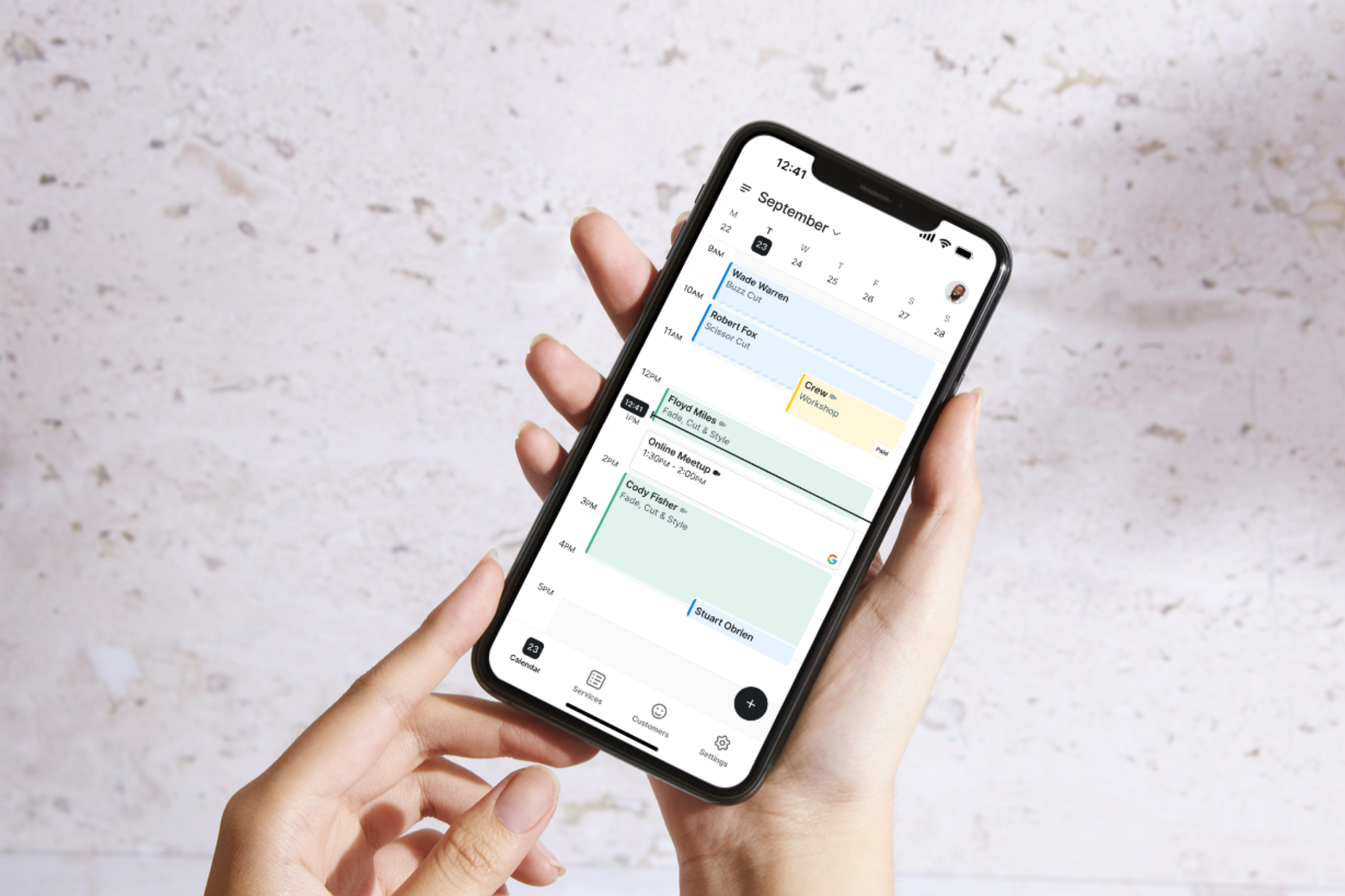 hands holding phone, Setmore calendar on screen