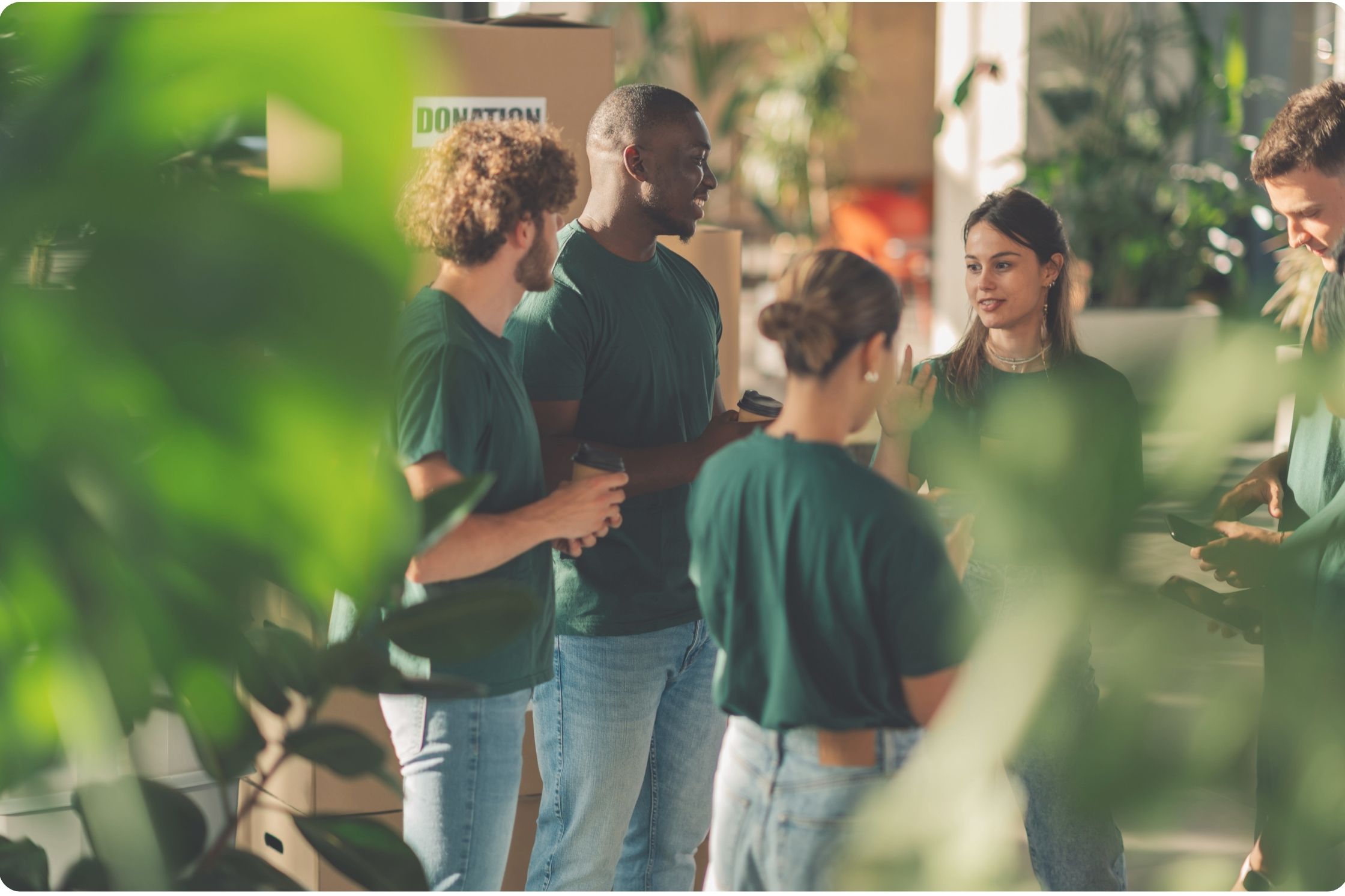 a group of people wearing green t-shirts, working for a charity, having a discussion