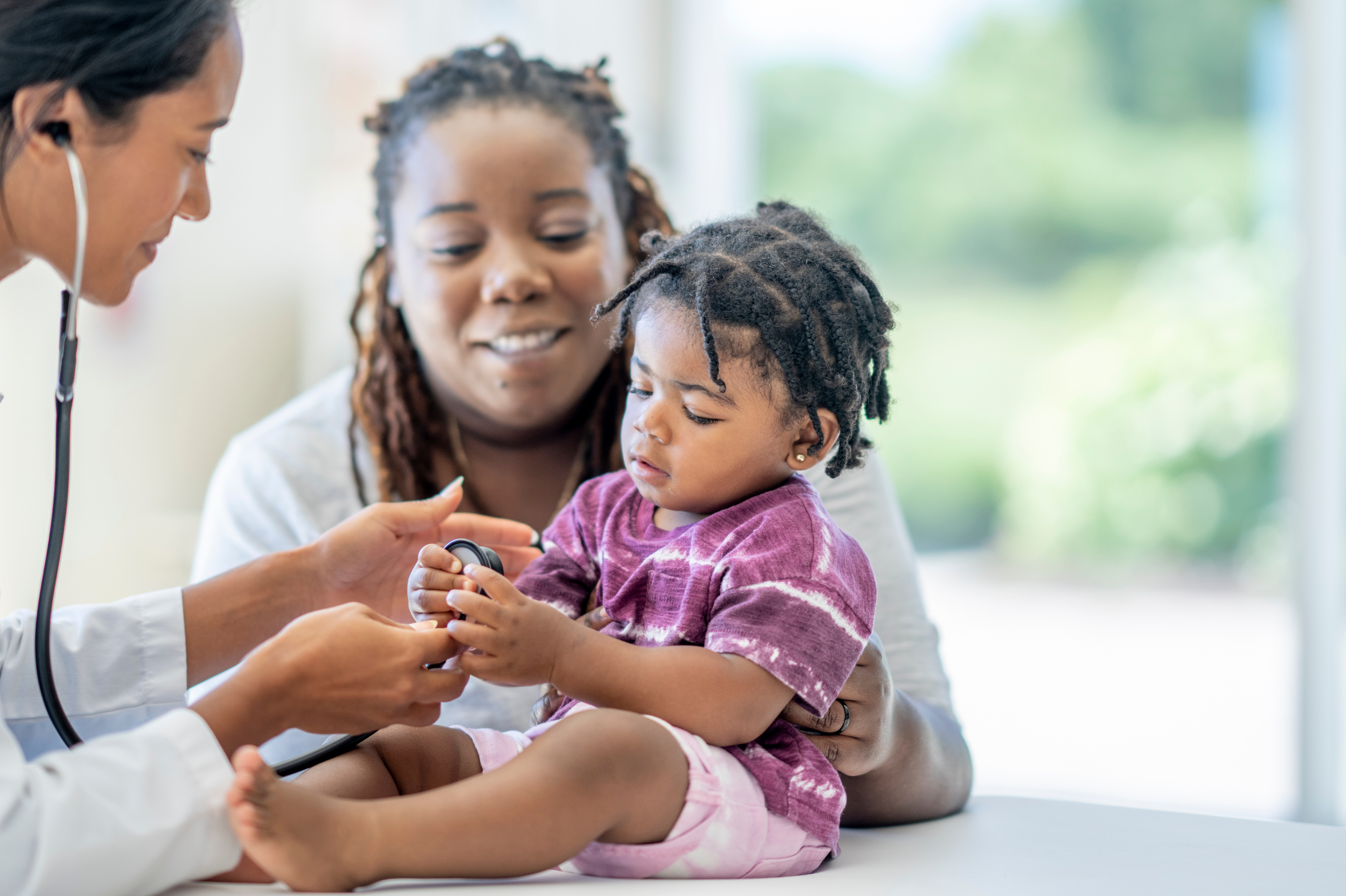 mother holding son, son holding doctor stethoscope, doctor smiling  
