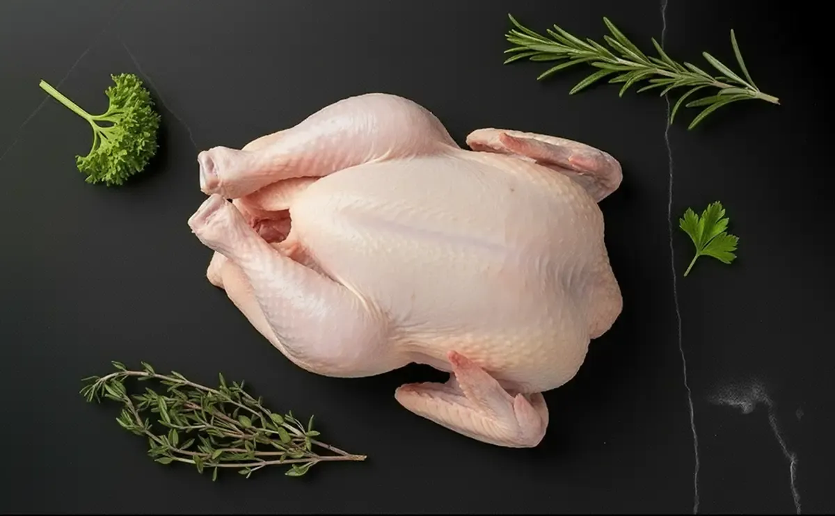 avicole.webp Fuso di pollo crudo, viole del pensiero colorate e bacche di goji su elegante sfondo scuro.