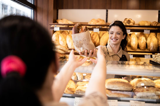 Baker handing bread to customer