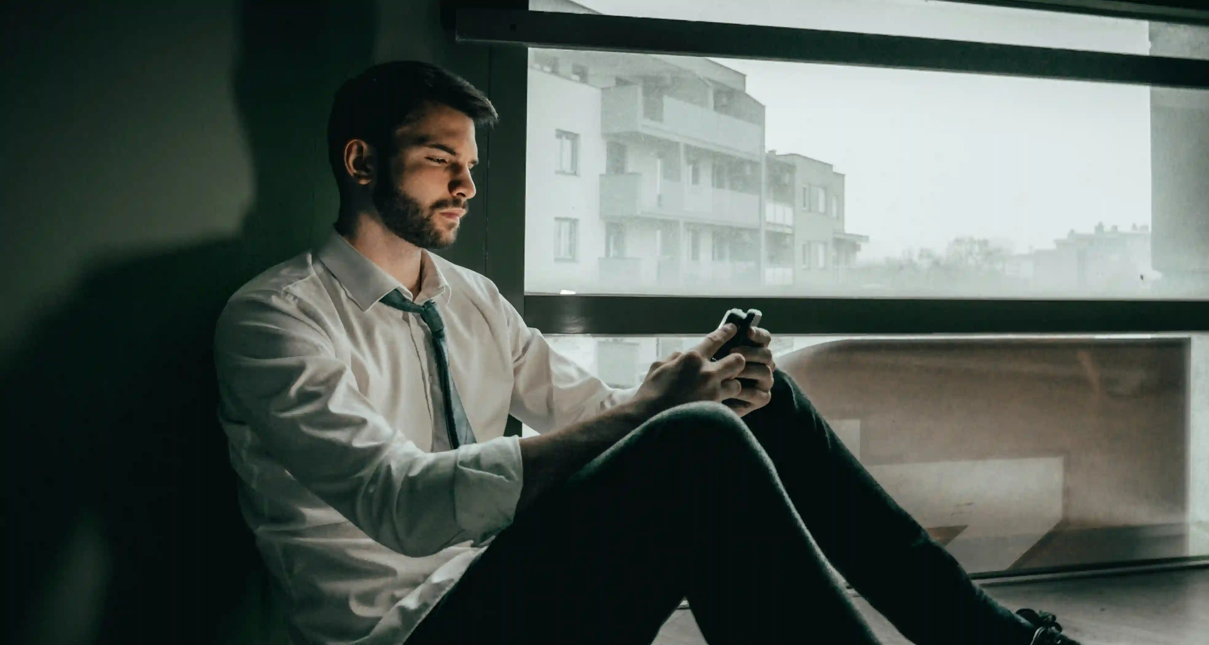 Man brooding as he looks at his phone